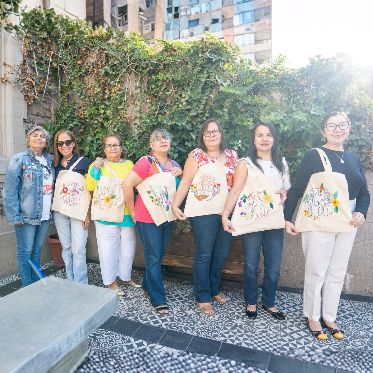 Alumnas con sus totebags bordadas al final del taller, en el patio de la casona de Ñuñoa